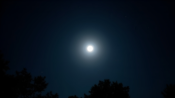 Bright full moon glowing vividly against a clear night sky with silvery illuminated clouds