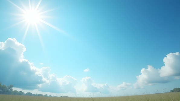 Clear Blue Sky with Fluffy White Clouds Over Sunlit Landscape