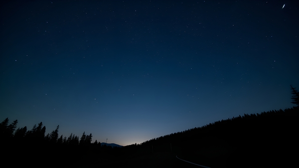 A clear night sky with bright stars twinkling over a serene dark landscape