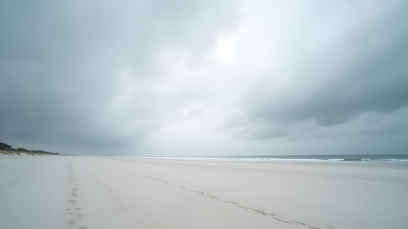 Expansive White Sandy Beach Under Overcast Sky