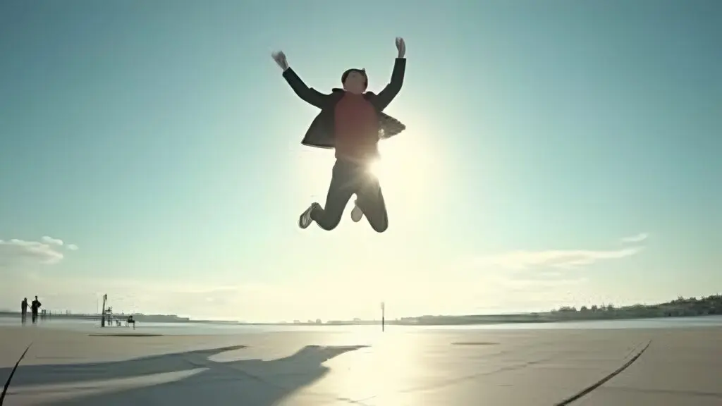 Joyful Individual Leaping Against Clear Sky