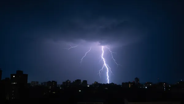 Lightning Bolt Striking Over Cityscape At Night