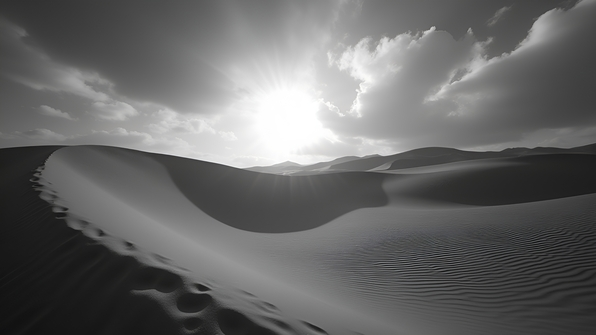High-contrast grayscale photograph of rolling sand dunes under a dramatic sky with sharp shadows and wind patterns