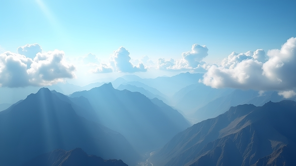 Panoramic view of rugged mountain ranges beneath fluffy white clouds under a bright blue daytime sky