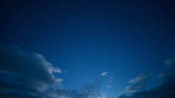 A serene night sky densely dotted with twinkling stars and wispy clouds drifting across a deep blue backdrop