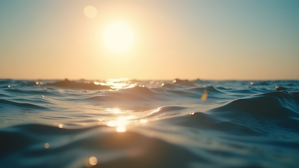 Serene ocean at golden hour with warm sunlight reflecting off gentle waves