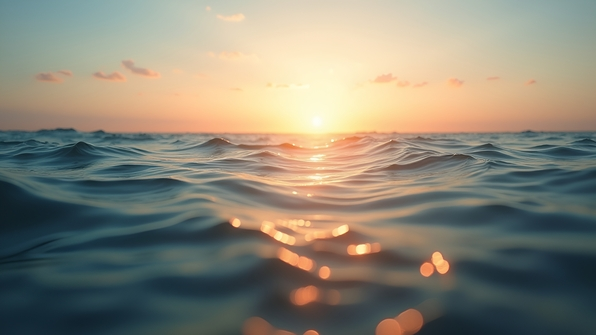 A serene ocean scene with golden hour light and gentle waves under a clear sky