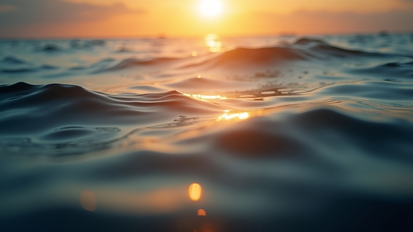 Close-up of shimmering water surface in warm golden hour light with gentle ripples and soft reflections