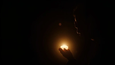 Silhouette Person Holding Glowing Light Source