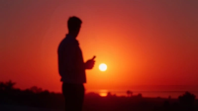 Silhouette Person Holding Object At Sunset