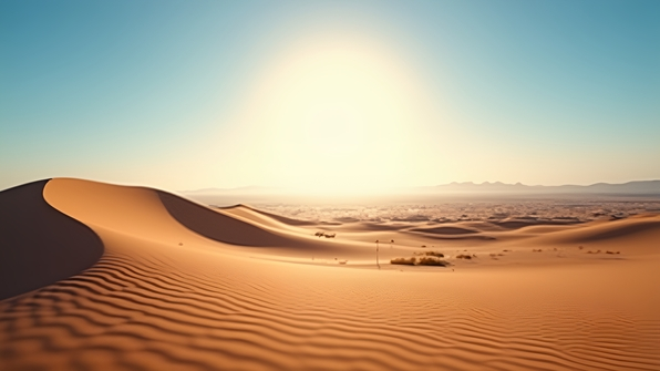 Sunlit sand dunes under a clear blue sky with soft shadows and wind patterns on golden desert surface