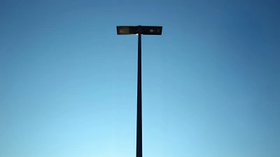 Tall Slender Black Metal Post Against Blue Sky