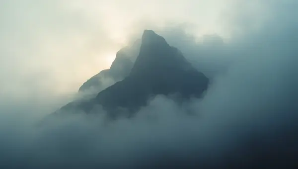 Towering Mountain in Dense Fog Under Soft Daylight