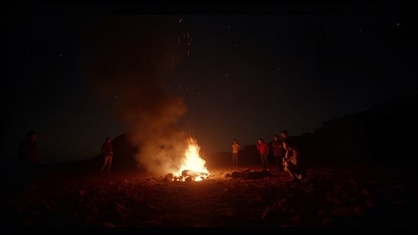 Warm bonfire glowing brightly at night surrounded by rocks and silhouettes of people under a starry sky