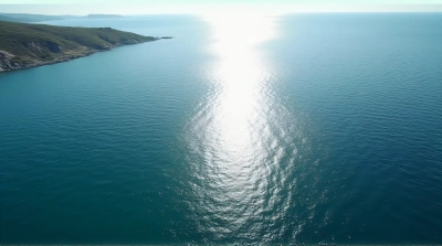 Aerial View Of Shimmering Water With Rocky Shoreline