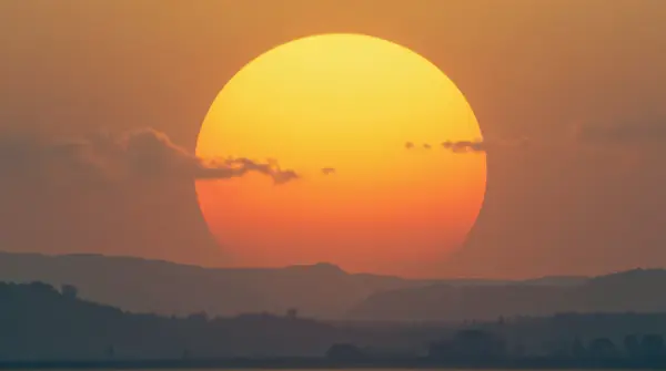 Amber Sun Rising Over Rolling Hills