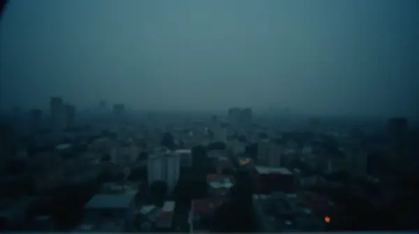 Soft-focus image of a dense city skyline at twilight with diffused lighting and indistinct buildings.