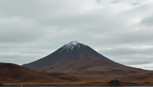 Brown White Peak Under Layered Gray Sky
