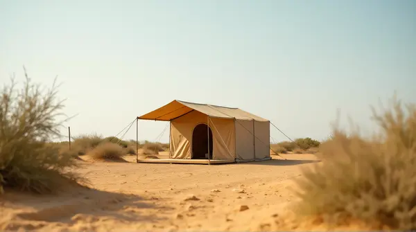 Beige canvas shelter standing alone on golden granular ground with sparse plants and vast open sky.