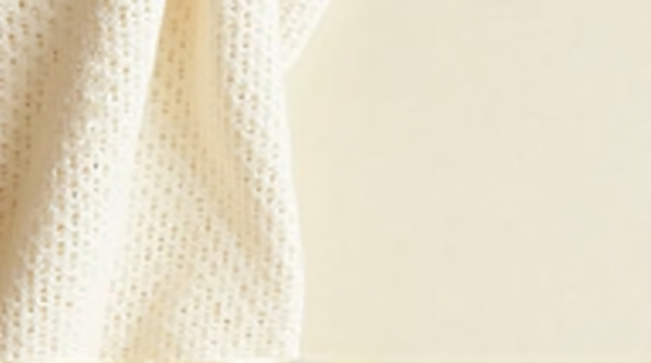 Close-Up Woven Textile Against Ivory Wall