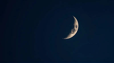 Crescent Moon Surface Detail Against Indigo Sky