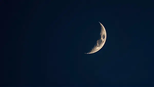 Crescent Moon Surface Detail Against Indigo Sky