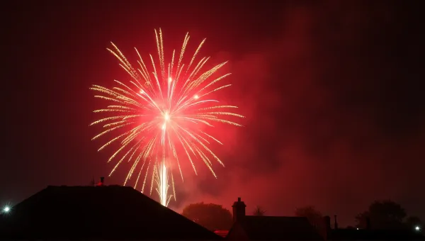 Crimson Amber Fireworks Burst With Rooftop Silhouette