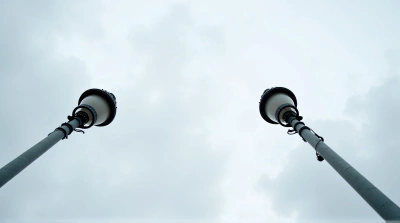 Detailed Metal Lampposts Converging Under Cloudy Sky