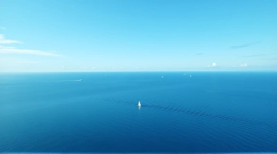 Expansive Blue Sea Under Clear Sky With Sailboat