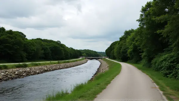 Flowing Stream Along Paved Path Under Cloudy Sky