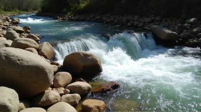 Flowing Stream Among Scattered Boulders In Sunlight