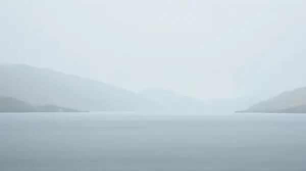 Foggy Water Expanses With Distant Hills Under Overcast Sky