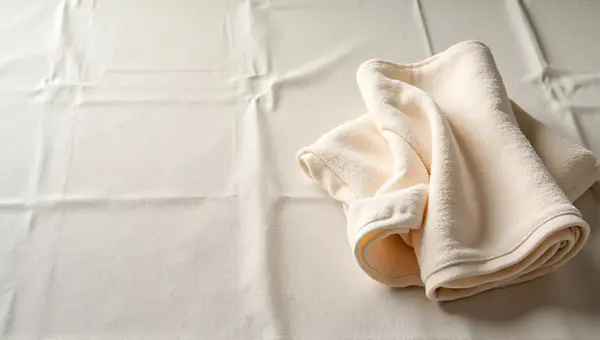 Folded Towel On Textured Linen Surface
