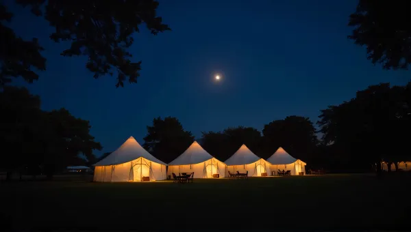 Glowing Tents On Grassy Clearing At Dusk