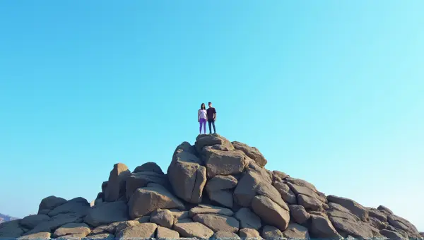 Hikers On Jagged Stone Outcrop Under Blue Sky