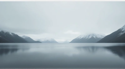 Icy Mountain Peaks Under Gray Sky With Calm Water