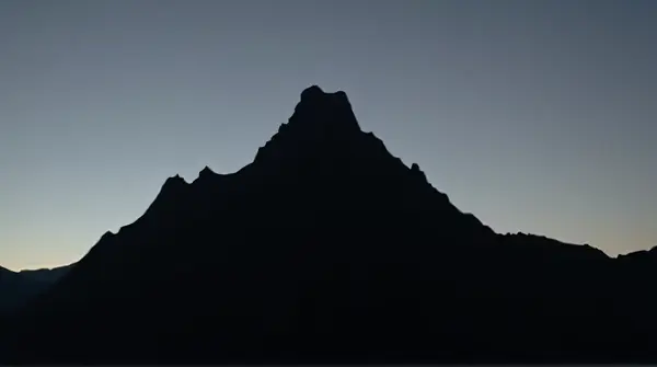 Jagged Peak Silhouette Against Fading Sky