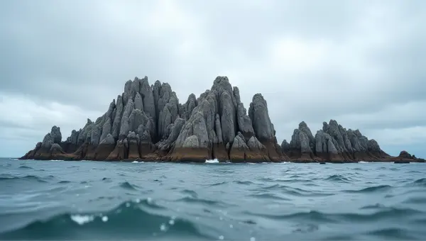 Jagged Rocks Textured Against Expansive Water Under Clouds