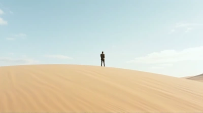 Lone Individual On Dune Under Wide Open Sky