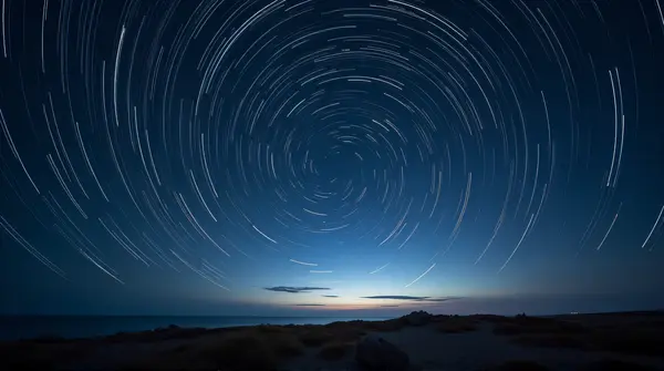 Swirling luminous arcs captured in long exposure against a dark celestial background above a distant horizon.