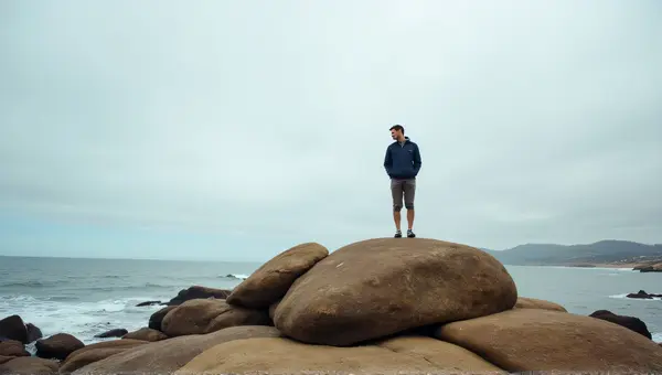 Man On Brown Rock Formation By Coastal Water