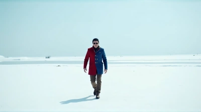 Man Crossing Icy Terrain In Bright Coat