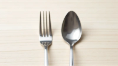 Metallic Spoon And Fork On Wooden Surface