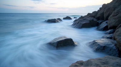 Misty Water Swirling Around Jagged Coastal Stones