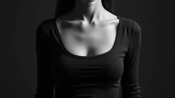 High contrast monochrome image of a figure wearing a textured scoop-neck garment highlighting silhouette contours.