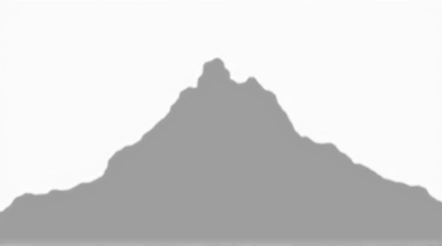 Monochrome Sharp Ridge Peak Against Pale Sky