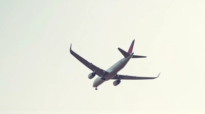 Passenger Jet Flying Overhead Against Sky