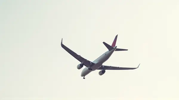 Passenger Jet Flying Overhead Against Sky