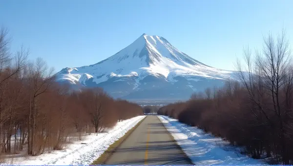 Paved Pathway Toward Ice-Capped Peak Under Clear Sky