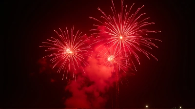 Red Firework Bursts Exploding Against Black Sky